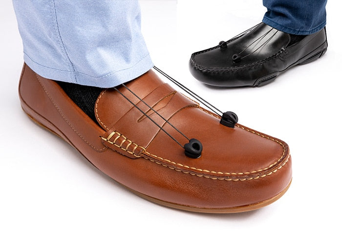 SaeboStep foot drop braces under two men's pant legs with bands attached to brown and black loafer.