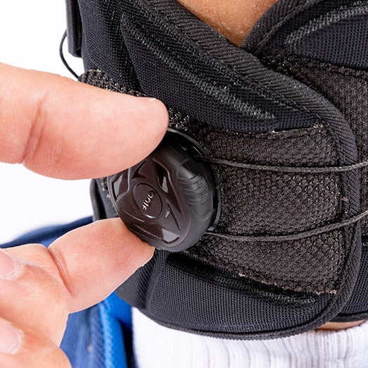 Single hand adjusting the ankle cuff dial of the SaeboStep AFO foot drop brace.