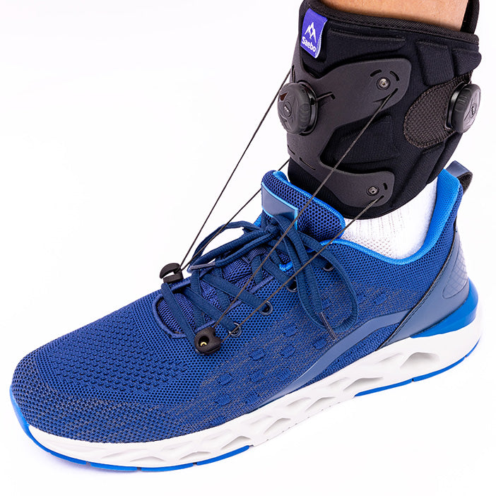 Person wearing SaeboStep drop foot brace with bands attached to blue sneaker.