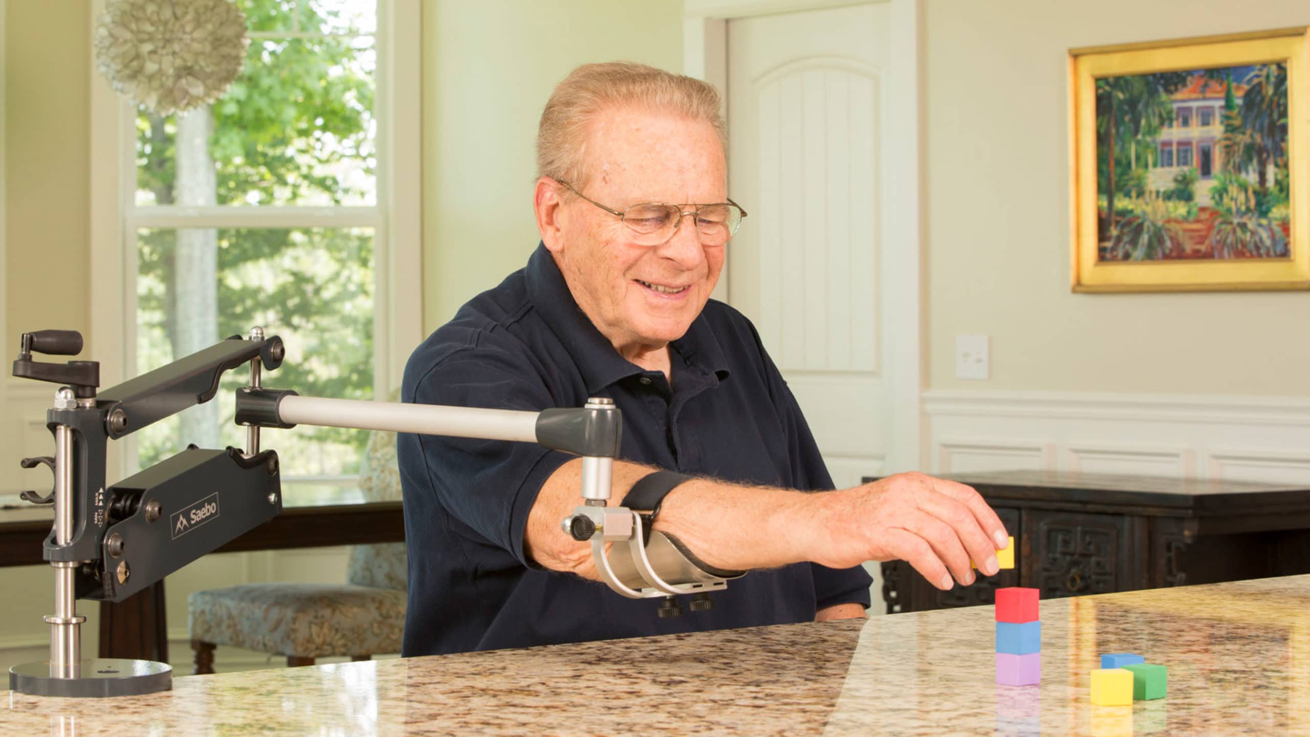 Older man using SaeboMAS Mini